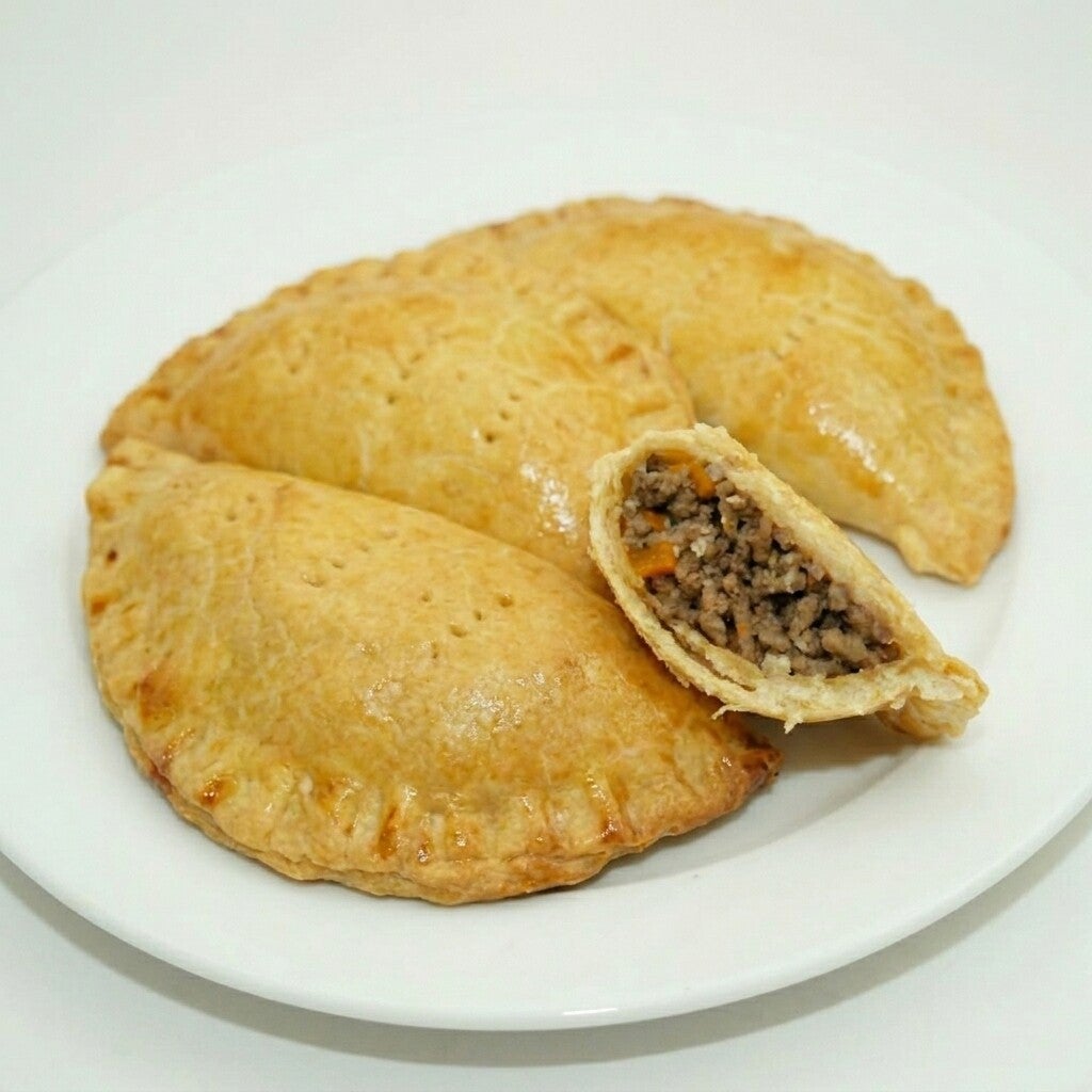 Golden Nigerian meat pie pastry served on a plate in Loganville, GA